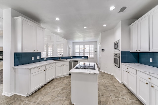 kitchen featuring sink, stainless steel appliances, a kitchen island, kitchen peninsula, and white cabinets