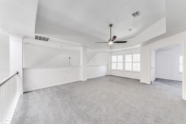 unfurnished living room with ceiling fan, a raised ceiling, and light carpet