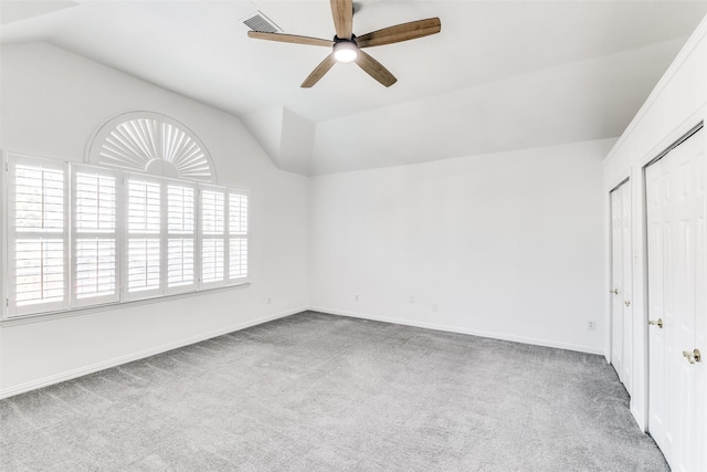 spare room with carpet floors, vaulted ceiling, and ceiling fan