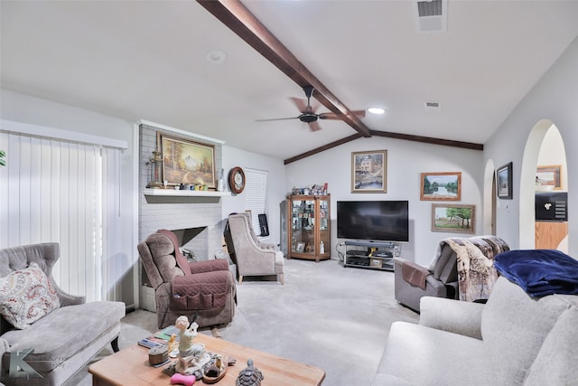 living room with carpet floors, a brick fireplace, ceiling fan, and vaulted ceiling with beams