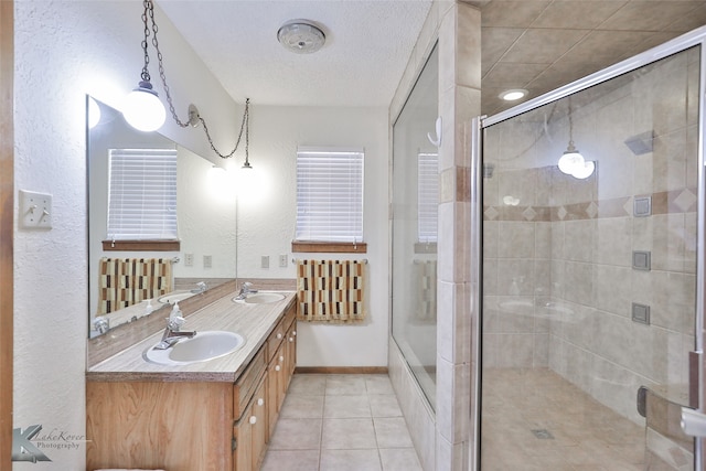 bathroom with double vanity, walk in shower, and tile patterned floors