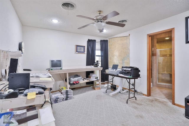 carpeted home office with a textured ceiling and ceiling fan