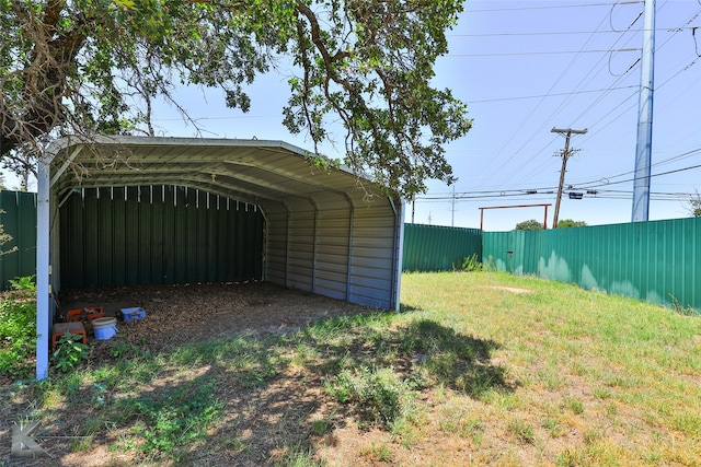 view of outdoor structure with a lawn and a carport