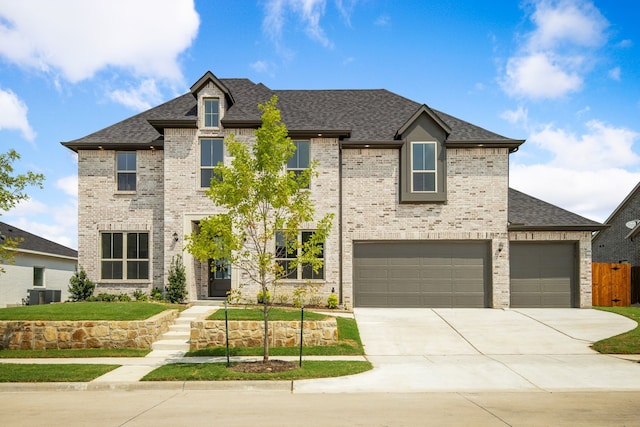 view of front of house featuring a garage and central AC