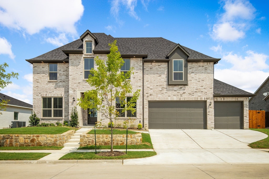 view of front of house featuring a garage and central AC