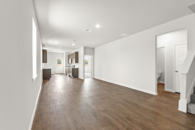 unfurnished living room with dark wood-type flooring