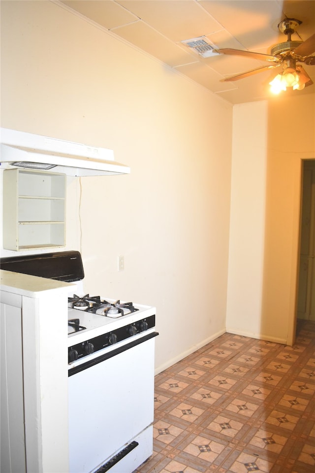 kitchen featuring white gas stove, light tile patterned floors, ceiling fan, and custom range hood