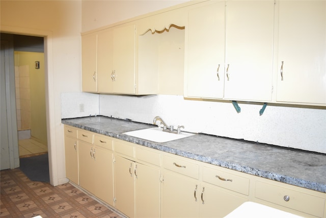 kitchen featuring sink, tile patterned floors, and backsplash