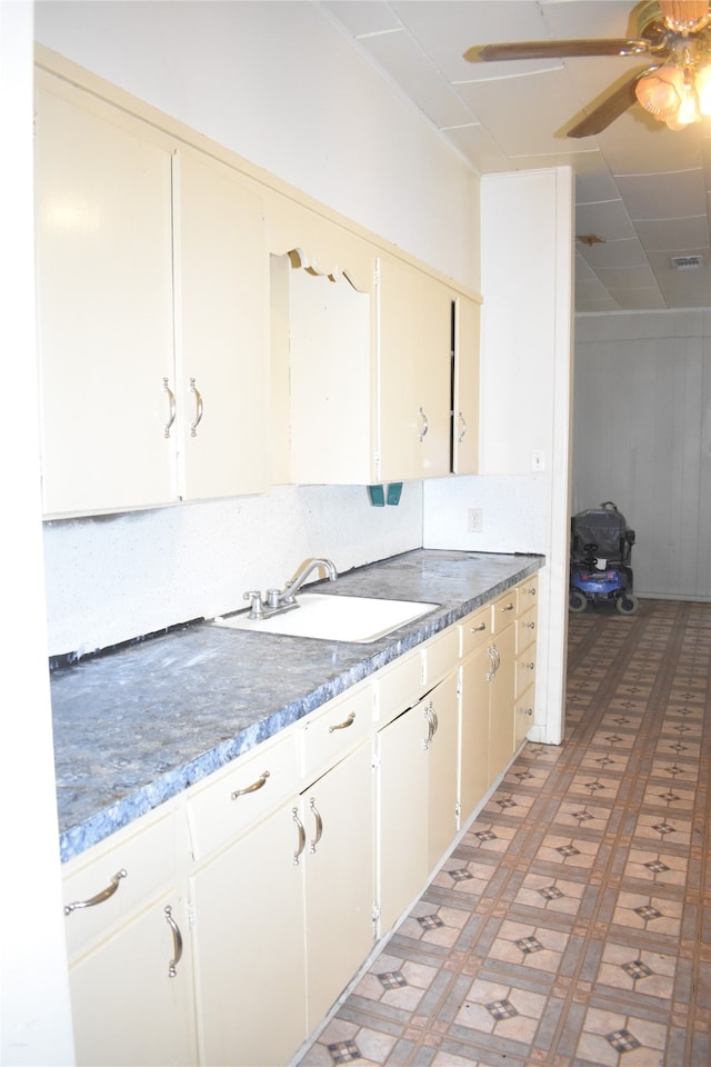 kitchen featuring white cabinets, sink, and ceiling fan