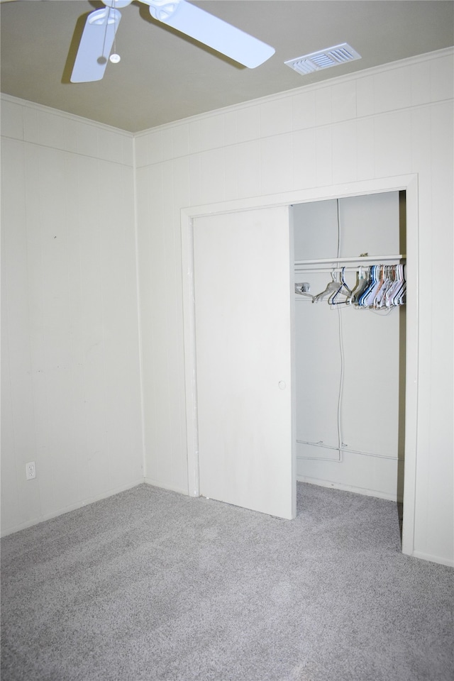 unfurnished bedroom with carpet, ceiling fan, and a closet