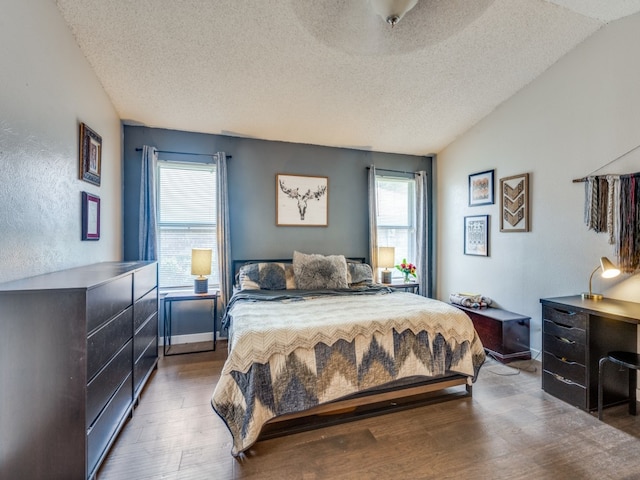 bedroom featuring a textured ceiling, multiple windows, and wood-type flooring