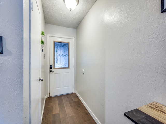 doorway featuring a textured ceiling and dark hardwood / wood-style flooring