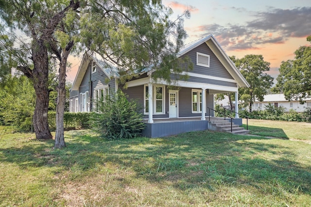 view of front of house with a porch and a yard