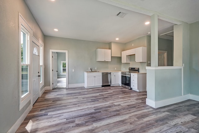 kitchen featuring appliances with stainless steel finishes, sink, light hardwood / wood-style floors, and white cabinets