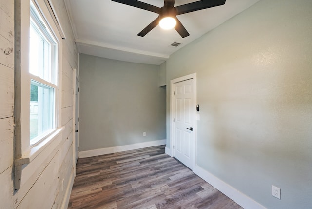 unfurnished room featuring ceiling fan, dark hardwood / wood-style floors, and a wealth of natural light