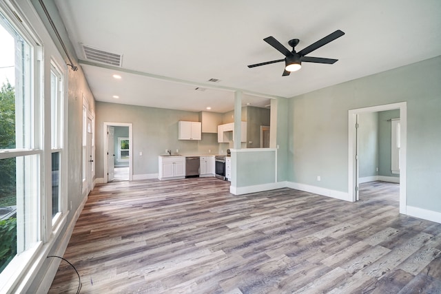 unfurnished living room with ceiling fan, sink, and light hardwood / wood-style flooring