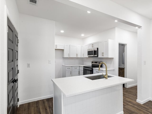 kitchen featuring appliances with stainless steel finishes, dark hardwood / wood-style flooring, white cabinetry, and tasteful backsplash