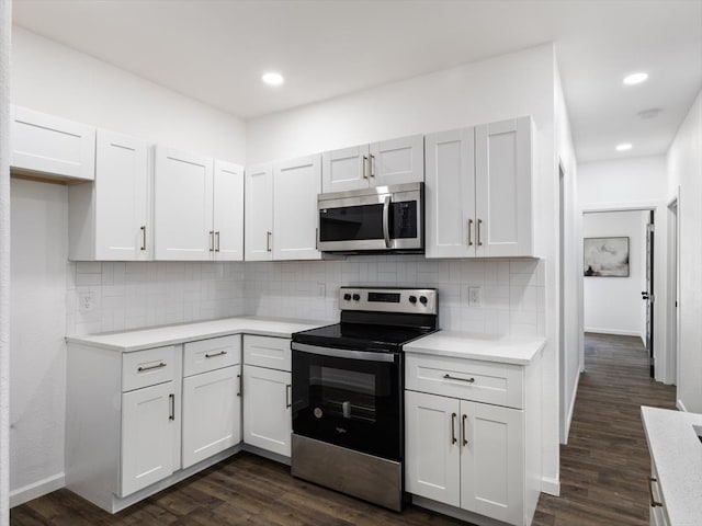 kitchen with decorative backsplash, dark wood-type flooring, stainless steel appliances, and white cabinets