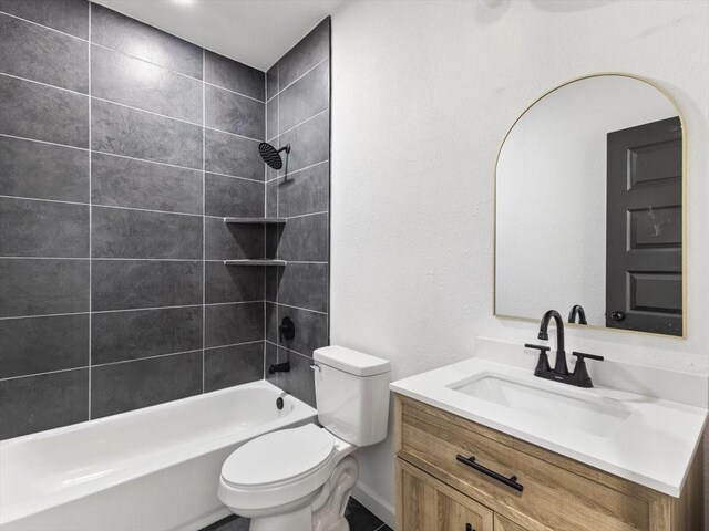 full bathroom featuring vanity, tiled shower / bath, and toilet