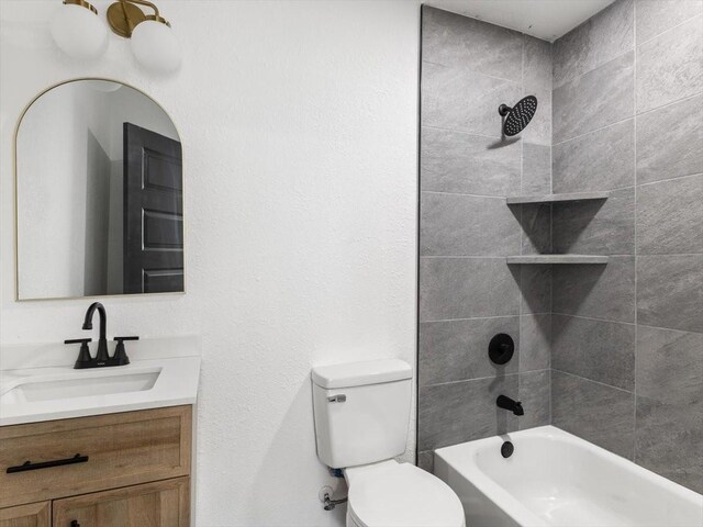 full bathroom with vanity, tiled shower / bath, and toilet