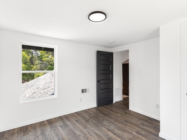 spare room featuring dark wood-type flooring