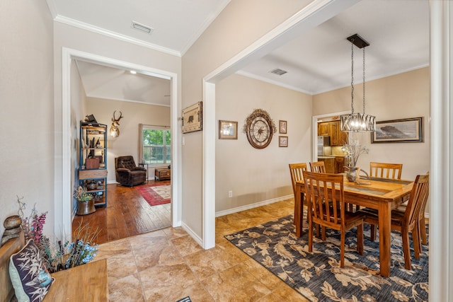 tiled dining room with a chandelier and ornamental molding