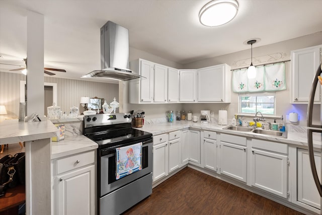 kitchen featuring electric stove, pendant lighting, dark hardwood / wood-style floors, ceiling fan, and wall chimney range hood