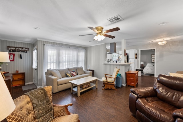 living room featuring ceiling fan, dark wood-type flooring, and crown molding