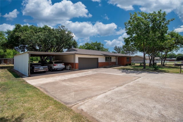 ranch-style house featuring a garage, a front lawn, and a carport