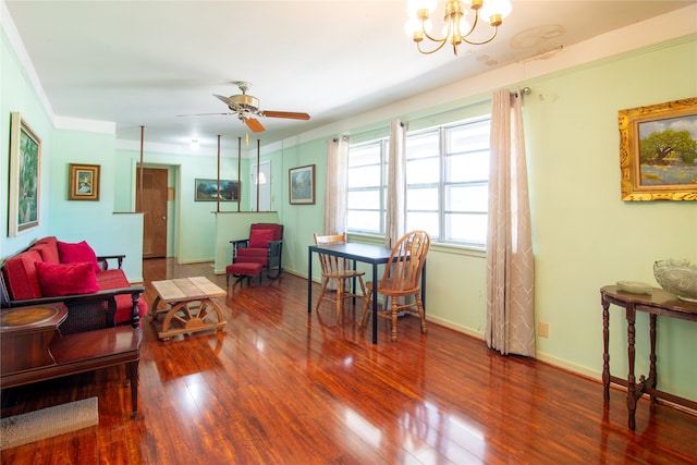 living room with hardwood / wood-style floors, crown molding, and ceiling fan with notable chandelier