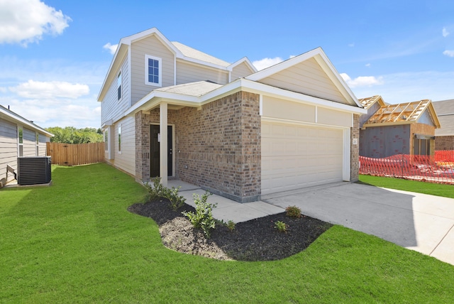 view of front of home featuring a front yard, cooling unit, and a garage