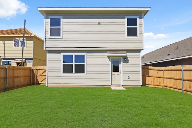 rear view of house featuring a lawn