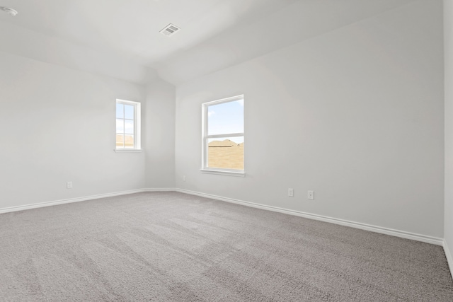 unfurnished room with carpet flooring and vaulted ceiling