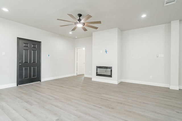 unfurnished living room featuring heating unit, light hardwood / wood-style floors, and ceiling fan