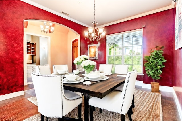 dining space featuring a chandelier, hardwood / wood-style flooring, and crown molding