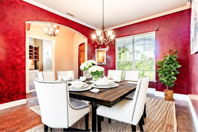 dining area with a chandelier, visible vents, arched walkways, and crown molding