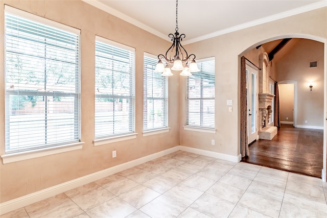 unfurnished dining area featuring a chandelier, hardwood / wood-style floors, lofted ceiling, and crown molding