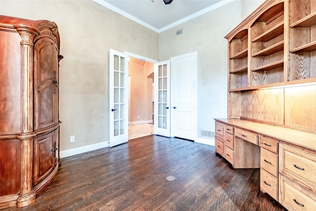 unfurnished office featuring french doors, built in desk, dark hardwood / wood-style floors, and crown molding