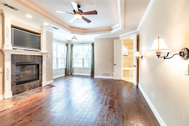 unfurnished living room featuring hardwood / wood-style flooring, ceiling fan, crown molding, and a tile fireplace