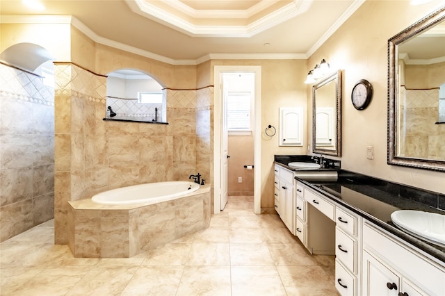 bathroom with tiled bath, ornamental molding, double vanity, and a sink