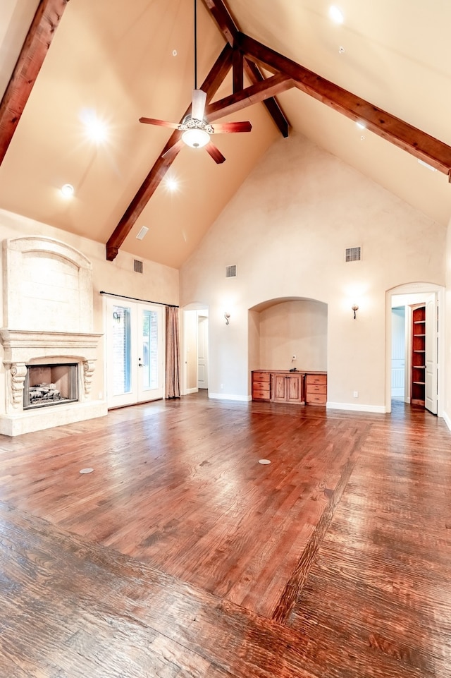 unfurnished living room featuring beam ceiling, dark hardwood / wood-style floors, high vaulted ceiling, and ceiling fan