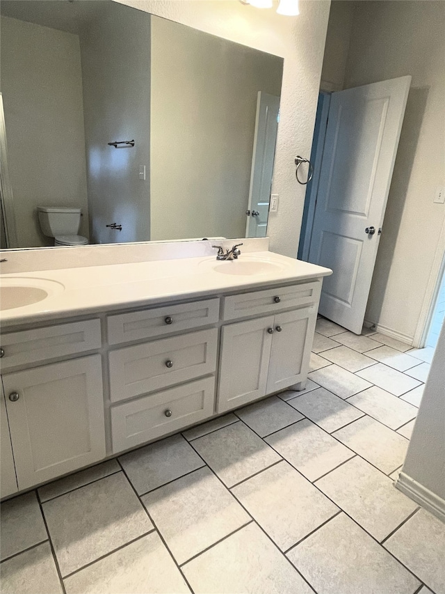 bathroom with tile patterned floors, vanity, and toilet