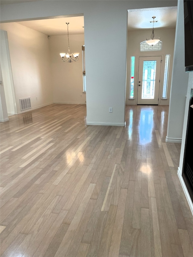 interior space with a notable chandelier and light hardwood / wood-style flooring