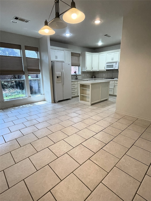 kitchen featuring sink, white appliances, decorative light fixtures, white cabinetry, and decorative backsplash