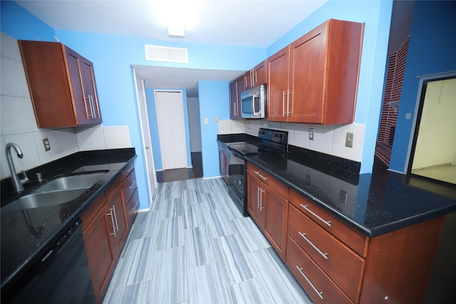 kitchen featuring dark stone countertops, sink, black appliances, and backsplash