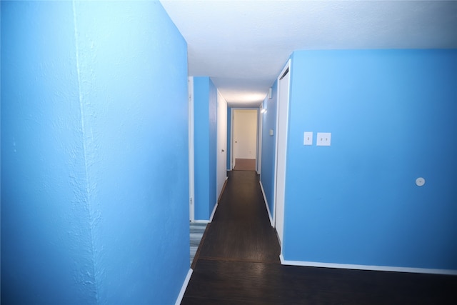 corridor featuring a textured ceiling and wood-type flooring