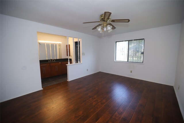 empty room with ceiling fan, sink, and dark hardwood / wood-style flooring