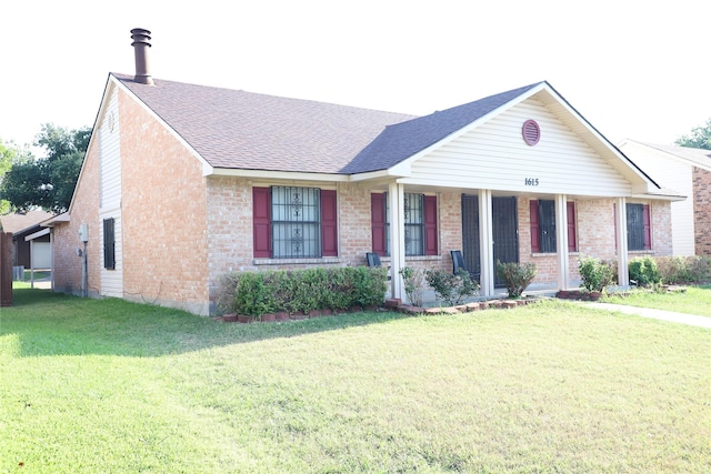 ranch-style home with covered porch, a shingled roof, a front lawn, and brick siding