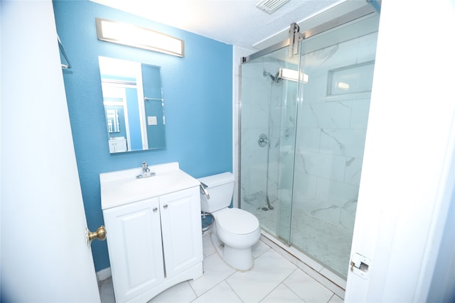 bathroom featuring a shower with shower door, vanity, tile patterned flooring, and toilet