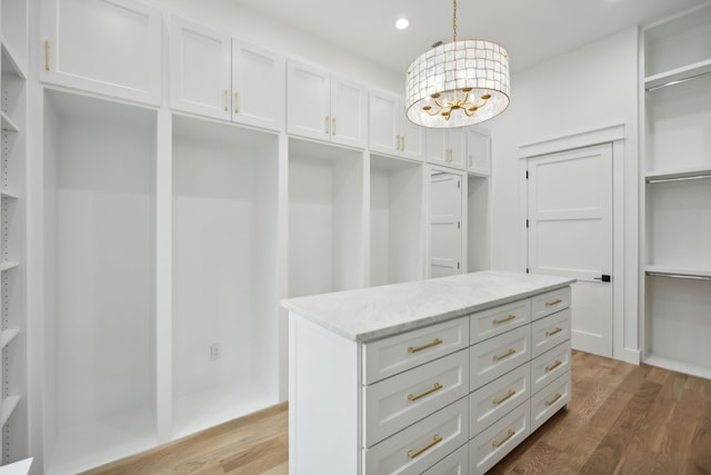 spacious closet featuring dark wood-type flooring and an inviting chandelier